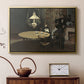 Gold floater framed canvas featuring an impressionist interior showing aftermath of dinner with soft light, displayed above a cabinet in a soft-toned living room.