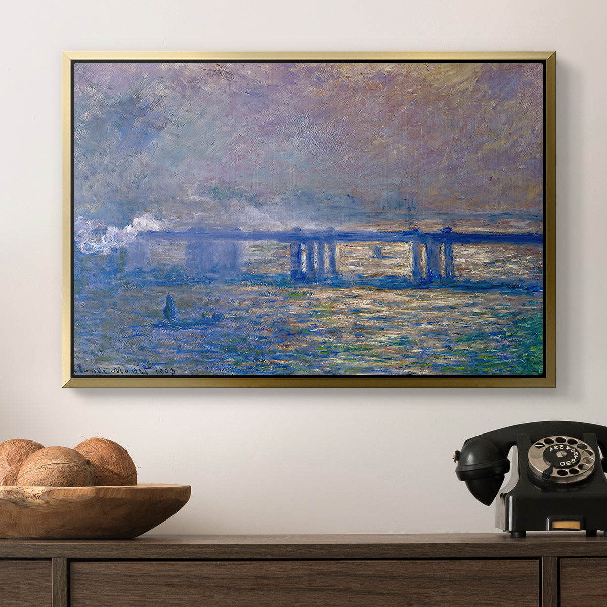 Charing Cross Bridge, 1903 by Claude Monet in a gold floater framed canvas displayed above a console table in a hallway, featuring a city bridge scene softened by mist and impressionist brushwork.