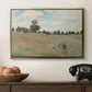 The Poppy Field near Argenteuil, 1873 by Claude Monet in a gold floater framed canvas displayed above a console table in a hallway, featuring a rural landscape with scattered figures among blooming flowers.