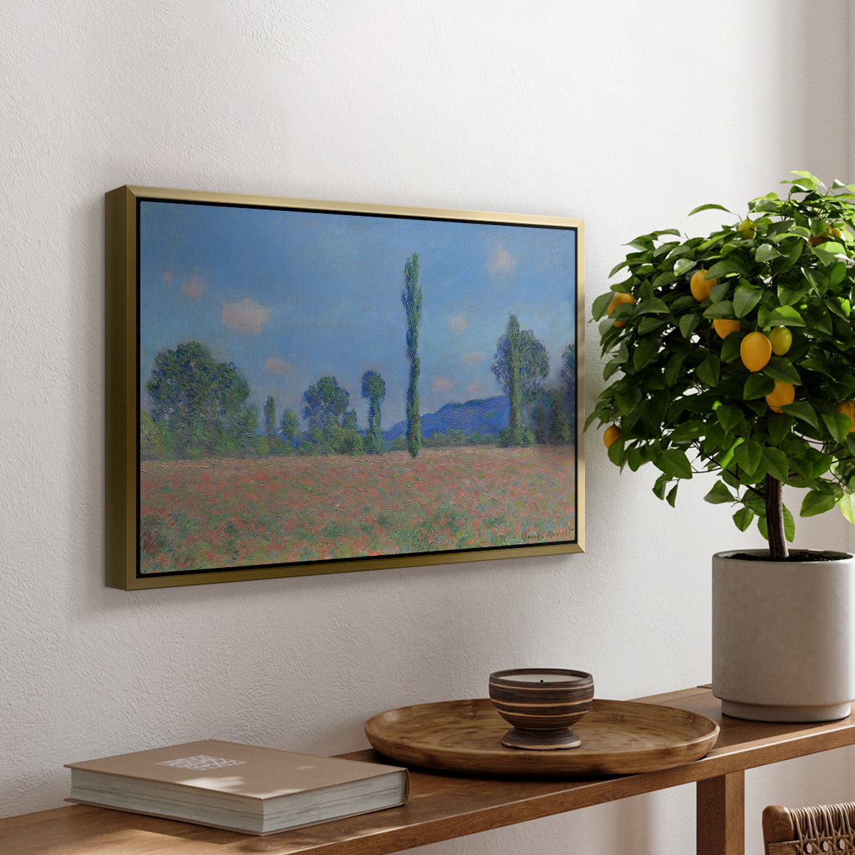 Poppy Field (Giverny), 1890-1891 by Claude Monet, presented in a gold floater framed canvas featuring an expansive field of red poppies with tall trees under blue sky, displayed above a hallway console table.