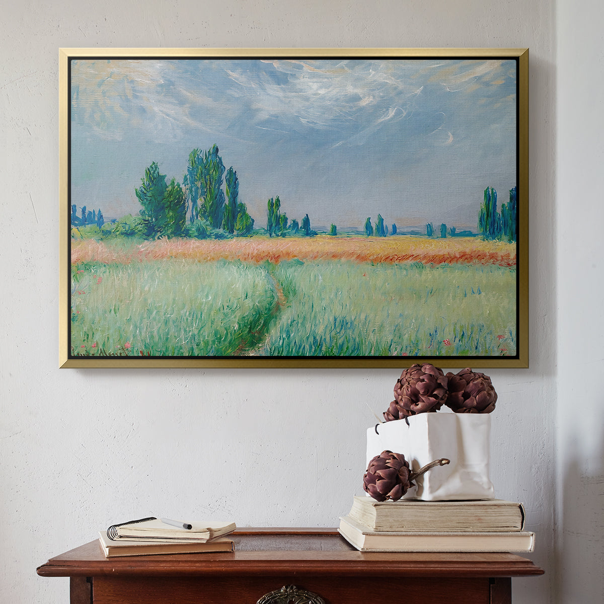 Gold floater framed canvas featuring The Wheat Field (Champ de Blé), 1881 by Claude Monet above an entryway table in a minimalist foyer.