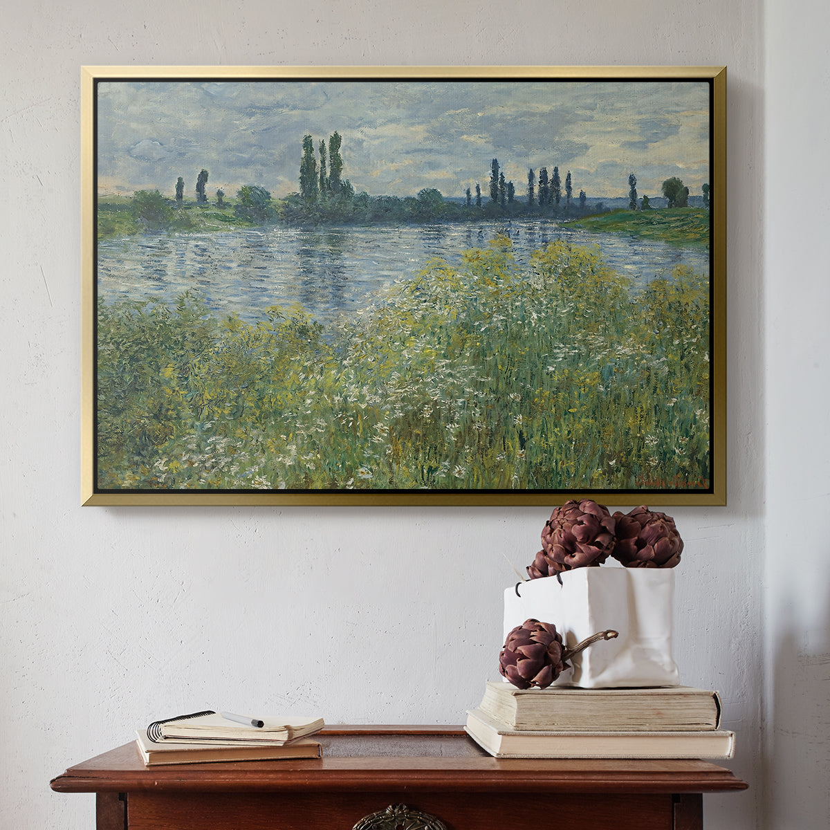 Gold floater framed canvas featuring Banks of the Seine, Vétheuil, 1880 by Claude Monet above an entryway table in a minimalist foyer.