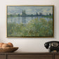 Banks of the Seine, Vétheuil, 1880 by Claude Monet in a gold floater framed canvas displayed above a console table in a hallway, featuring a natural landscape with calm water and soft foliage.