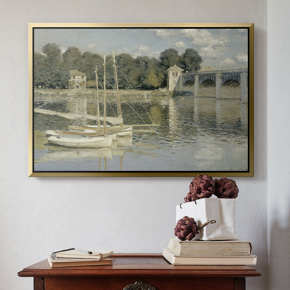 Gold floater framed canvas featuring The Bridge at Argenteuil, 1874 by Claude Monet above an entryway table in a minimalist foyer.
