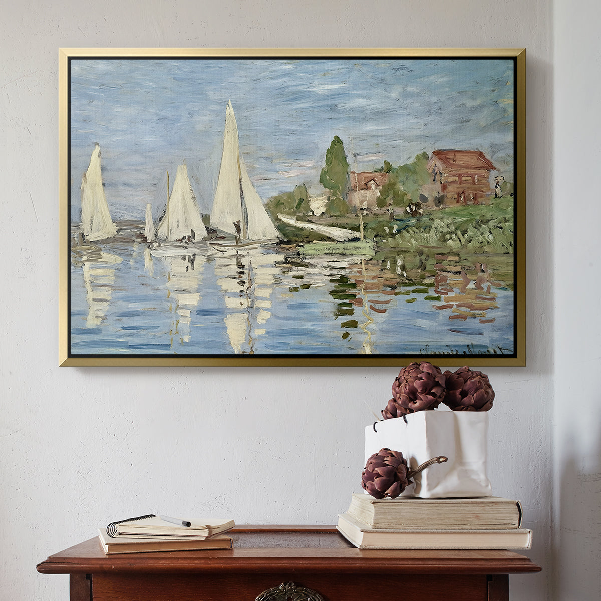Gold floater framed canvas featuring Regatta at Argenteuil, 1872 by Claude Monet above an entryway table in a minimalist foyer.