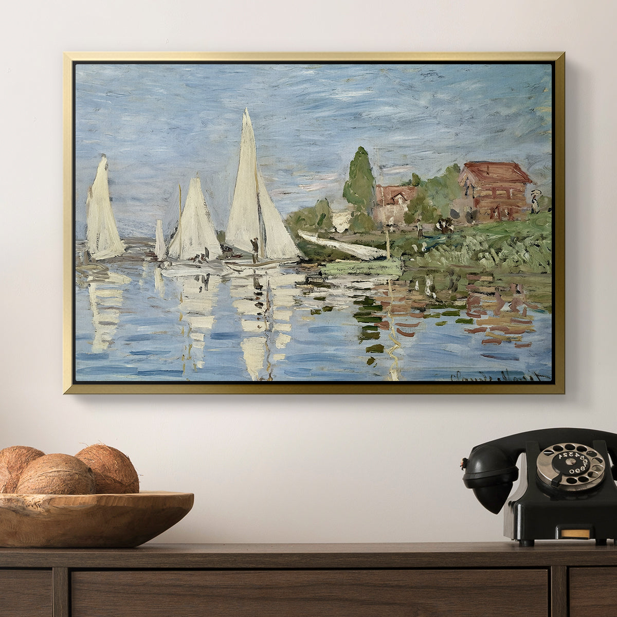 Regatta at Argenteuil, 1872 by Claude Monet in a gold floater framed canvas displayed above a console table in a hallway, featuring a dynamic nautical scene with boats moving across river.