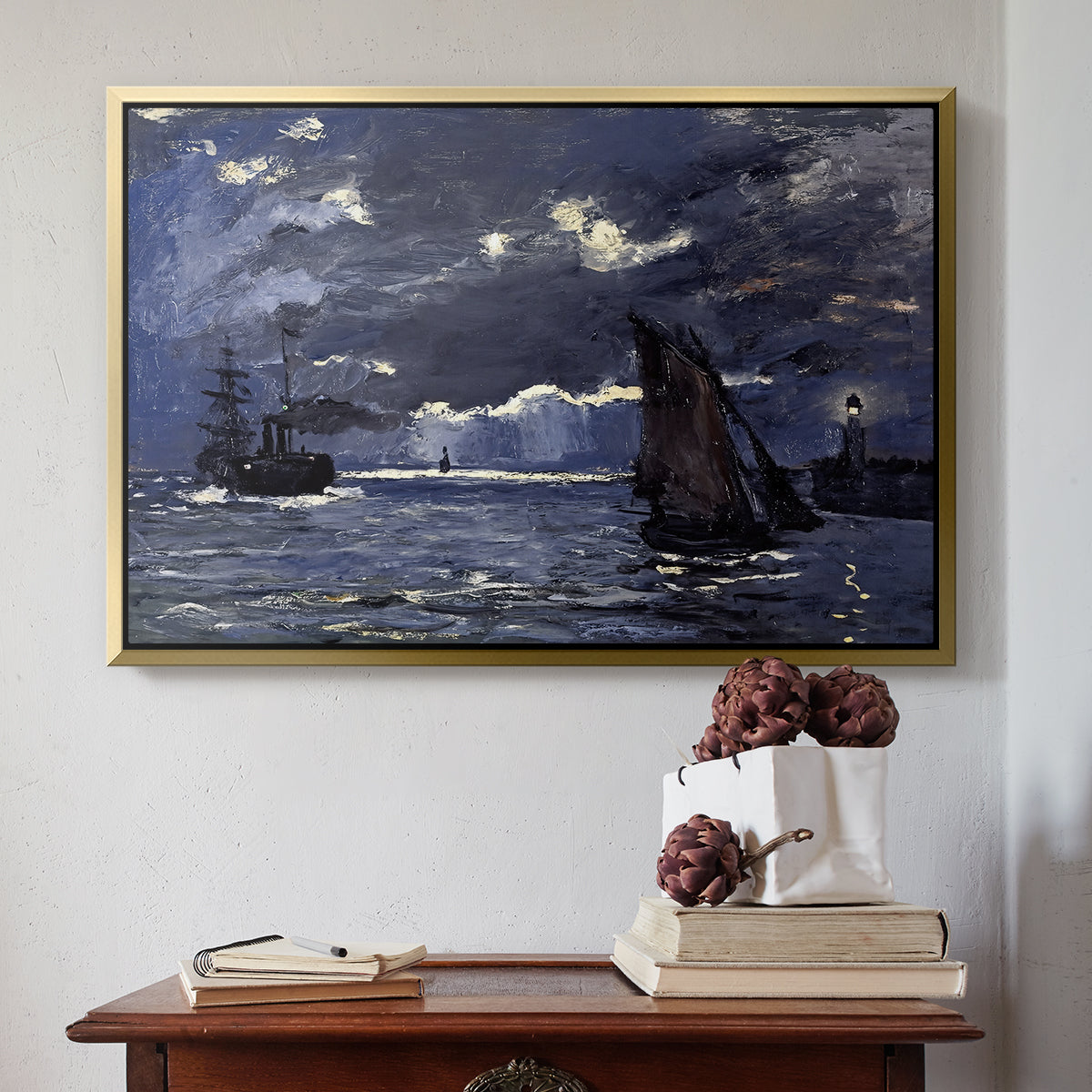 Gold floater framed canvas featuring A Seascape, Shipping by Moonlight, 1864 by Claude Monet above an entryway table in a minimalist foyer.