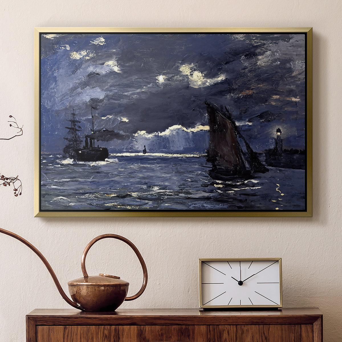Gold floater framed canvas featuring a dramatic ocean scene with light reflecting across water at night, displayed above a cabinet in a soft-toned living room.