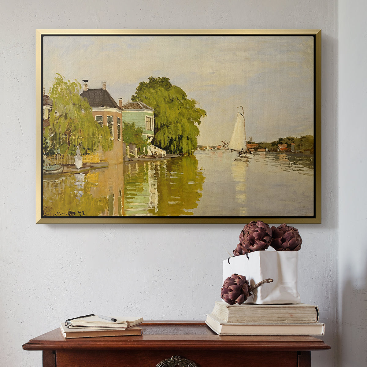 Gold floater framed canvas featuring Houses on the Achterzaan, 1871 by Claude Monet above an entryway table in a minimalist foyer.