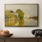 Houses on the Achterzaan, 1871 by Claude Monet in a gold floater framed canvas displayed above a console table in a hallway, featuring a peaceful village scene with houses bordering water.