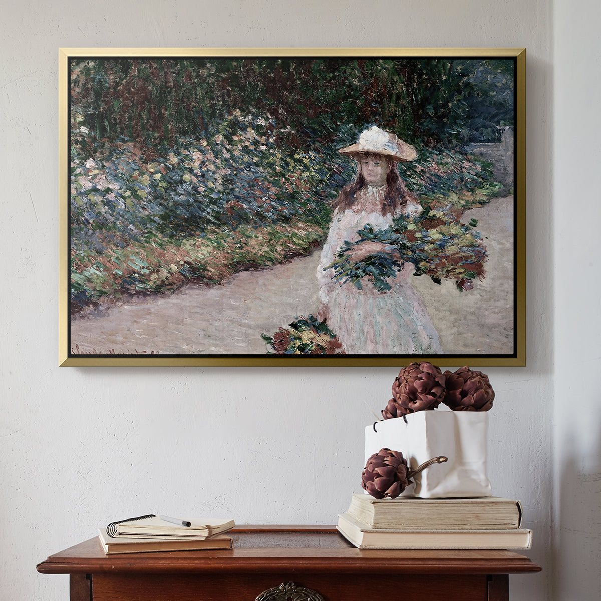 Gold floater framed canvas featuring Young Girl in the Garden at Giverny, 1888 by Claude Monet above an entryway table in a minimalist foyer.