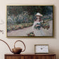 Gold floater framed canvas featuring a figure resting in colorful garden under soft light, displayed above a cabinet in a soft-toned living room.