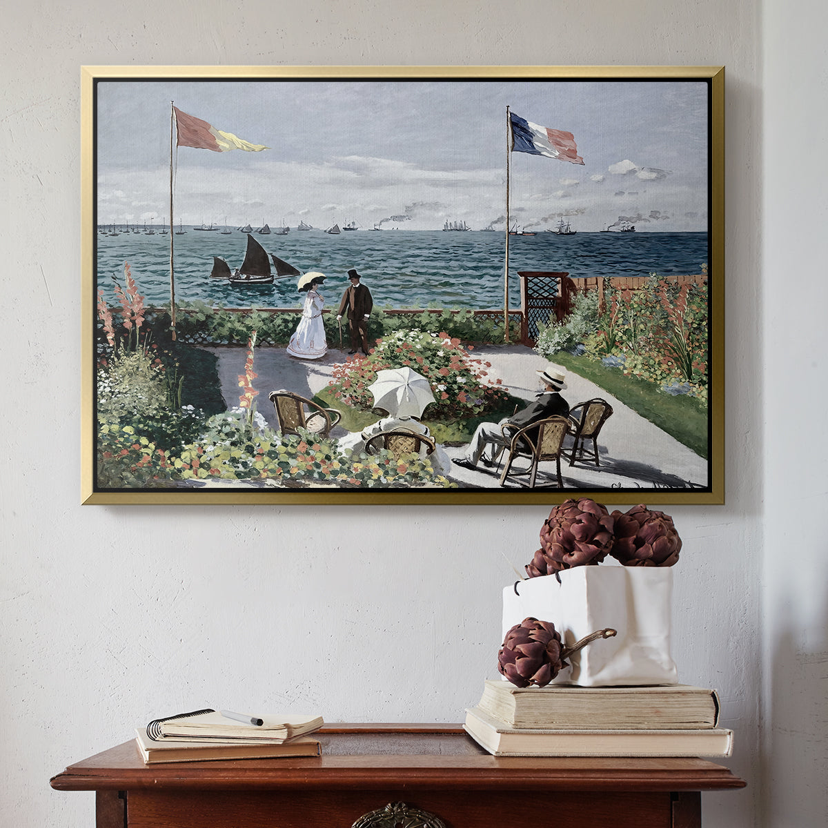 Gold floater framed canvas featuring Garden at Sainte-Adresse, 1867 by Claude Monet above an entryway table in a minimalist foyer.