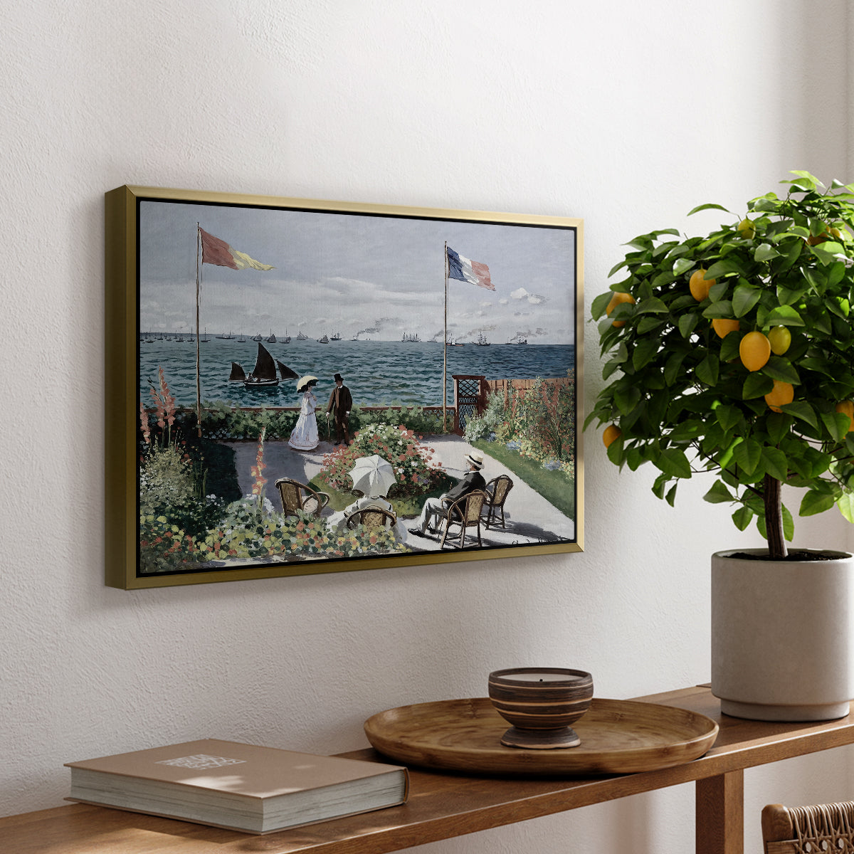 Garden at Sainte-Adresse, 1867 by Claude Monet, presented in a gold floater framed canvas featuring a seaside garden with flowers, flags, and figures overlooking the water, displayed above a hallway console table.