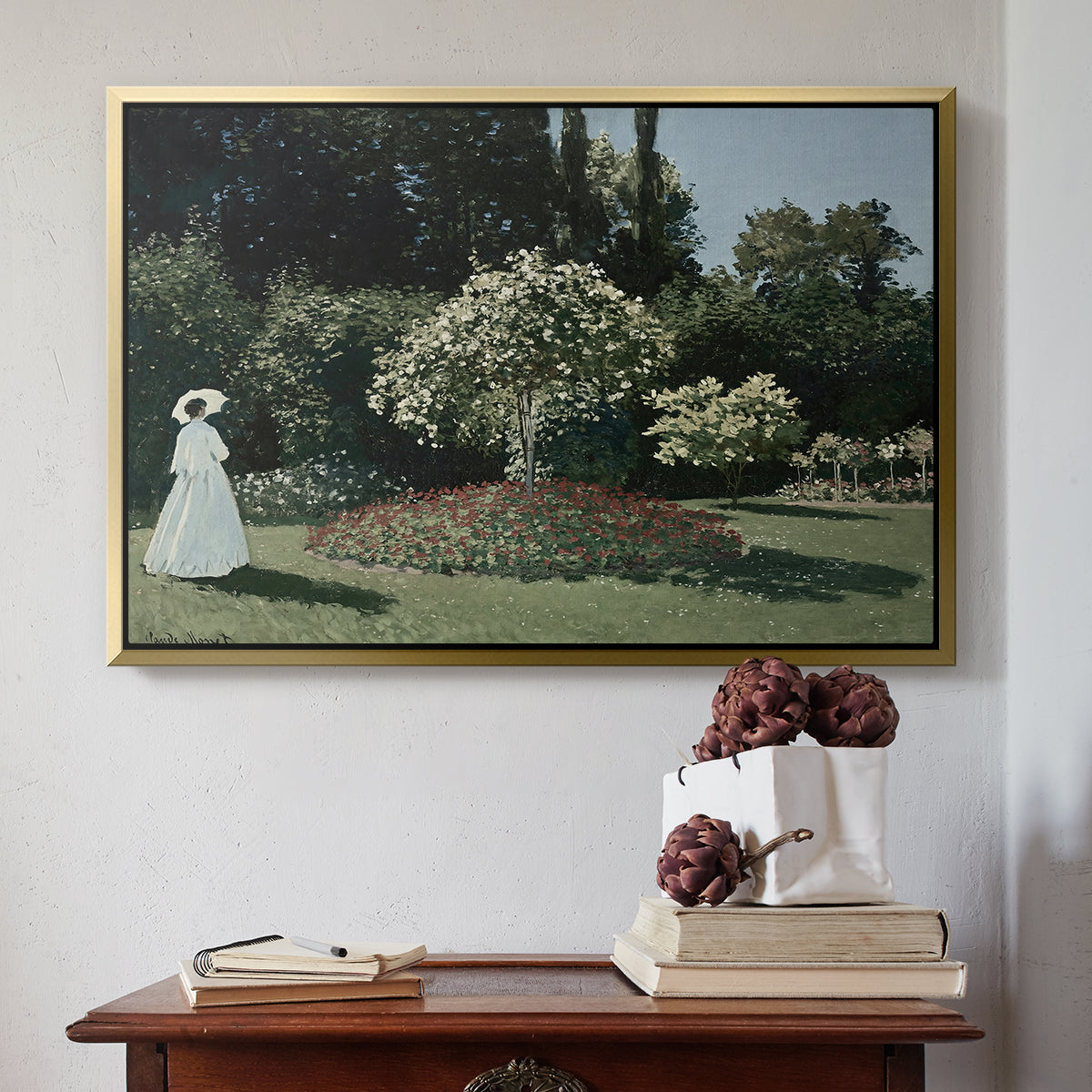 Gold floater framed canvas featuring Woman in the Garden, Sainte-Adresse, 1867 by Claude Monet above an entryway table in a minimalist foyer.
