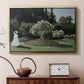 Gold floater framed canvas featuring an elegant woman posed outdoors among blooming plants, displayed above a cabinet in a soft-toned living room.