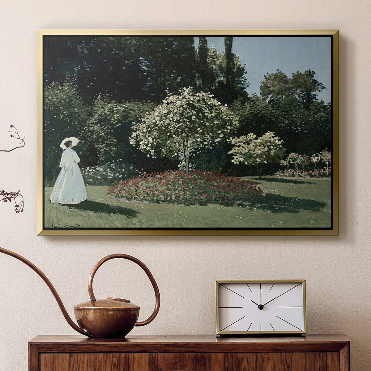 Gold floater framed canvas featuring an elegant woman posed outdoors among blooming plants, displayed above a cabinet in a soft-toned living room.
