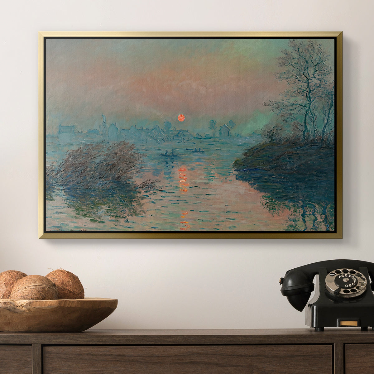 Sunset on the Seine at Lavacourt, Winter Effect, 1880 by Claude Monet in a gold floater framed canvas displayed above a console table in a hallway, featuring an atmospheric landscape combining cold tones and warm sky.