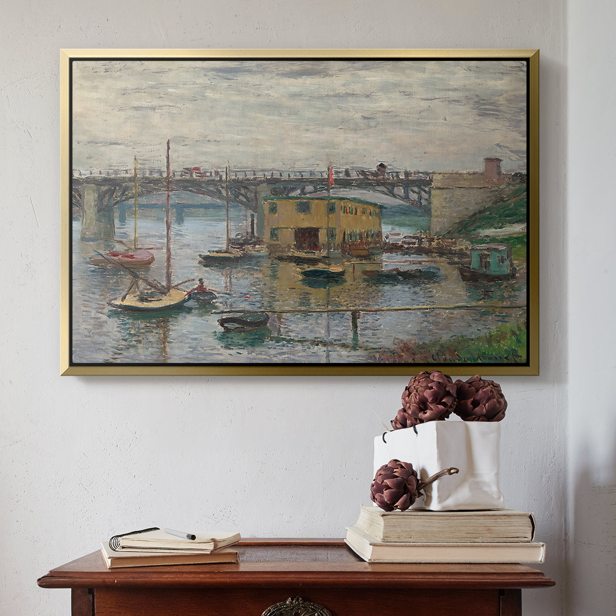 Gold floater framed canvas featuring Bridge at Argenteuil on a Gray Day, c. 1876 by Claude Monet above an entryway table in a minimalist foyer.