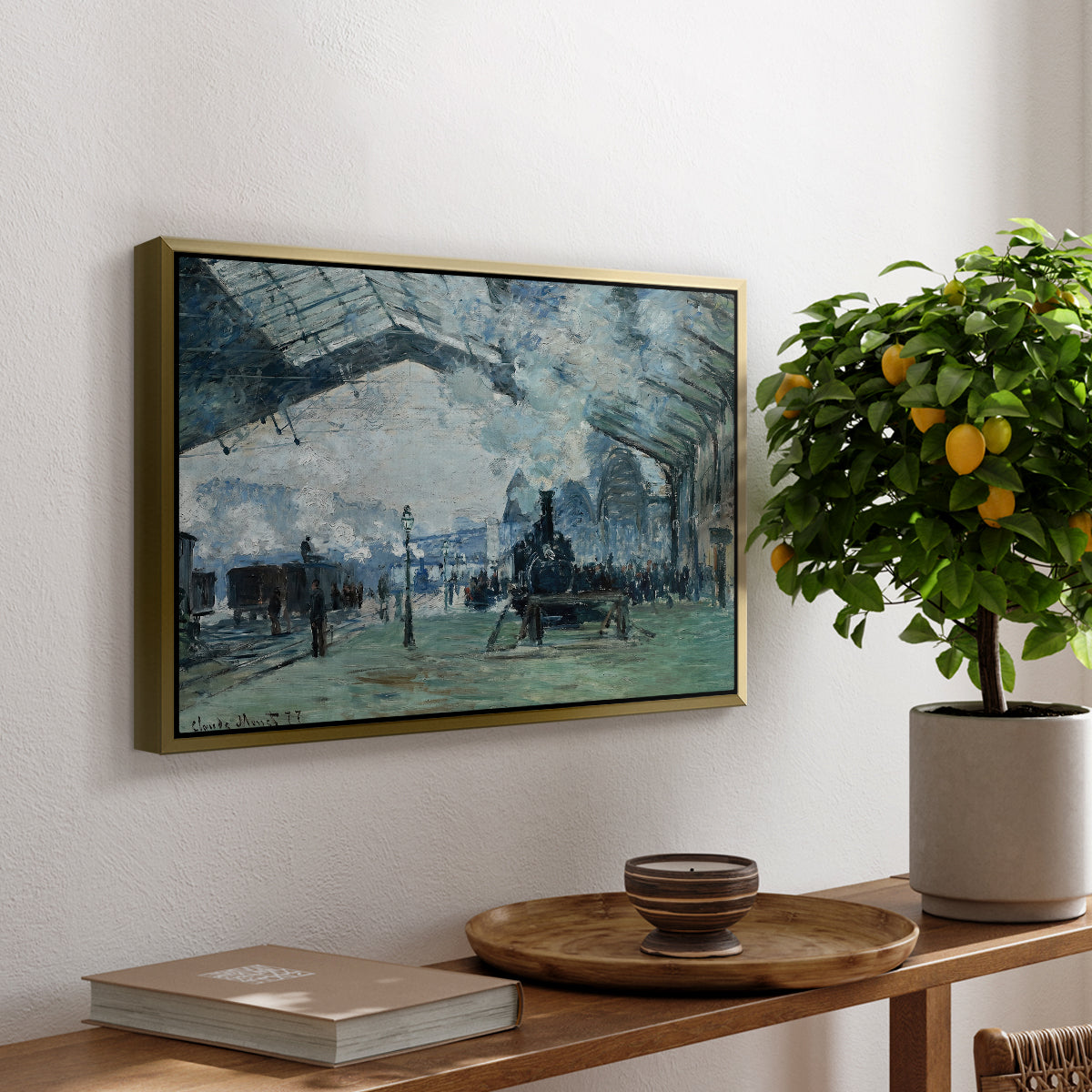 The Saint-Lazare Station, 1877 by Claude Monet, presented in a gold floater framed canvas featuring trains arriving under large arched station roof with billowing steam, displayed above a hallway console table.