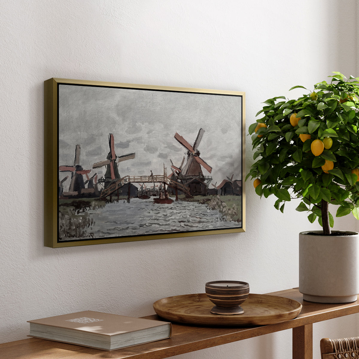Windmills near Zaandam, 1871 by Claude Monet, presented in a gold floater framed canvas featuring windmills standing beside water under open sky in rural landscape, displayed above a hallway console table.