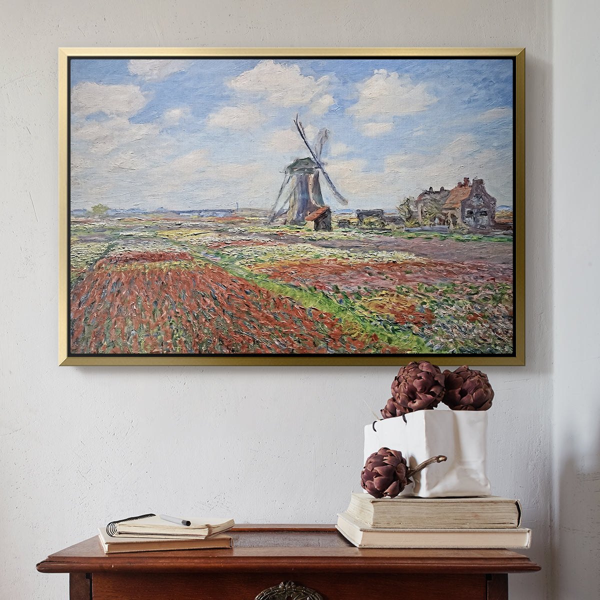 Gold floater framed canvas featuring Tulip Fields with the Rijnsburg Windmill, 1886 by Claude Monet above an entryway table in a minimalist foyer.