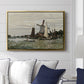 Windmill at Zaandam, 1871 by Claude Monet displayed above a sofa in a living room in a gold floater frame, featuring an impressionist depiction of windmill near riverbank.