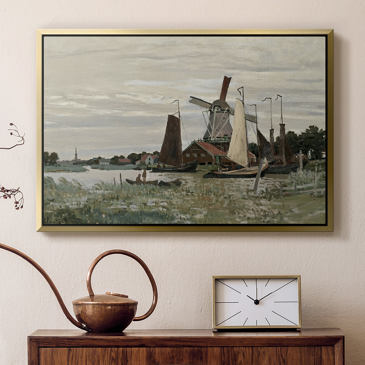 Gold floater framed canvas featuring a rustic scene with windmill and reflections in water, displayed above a cabinet in a soft-toned living room.