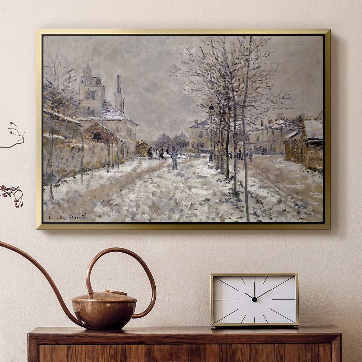 Gold floater framed canvas featuring a quiet boulevard blanketed in snow with distant figures, displayed above a cabinet in a soft-toned living room.