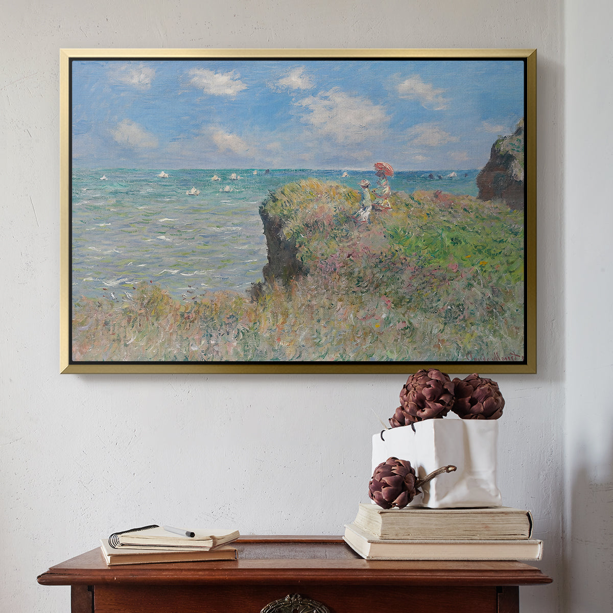 Gold floater framed canvas featuring The Cliff Walk at Pourville, 1882 by Claude Monet above an entryway table in a minimalist foyer.