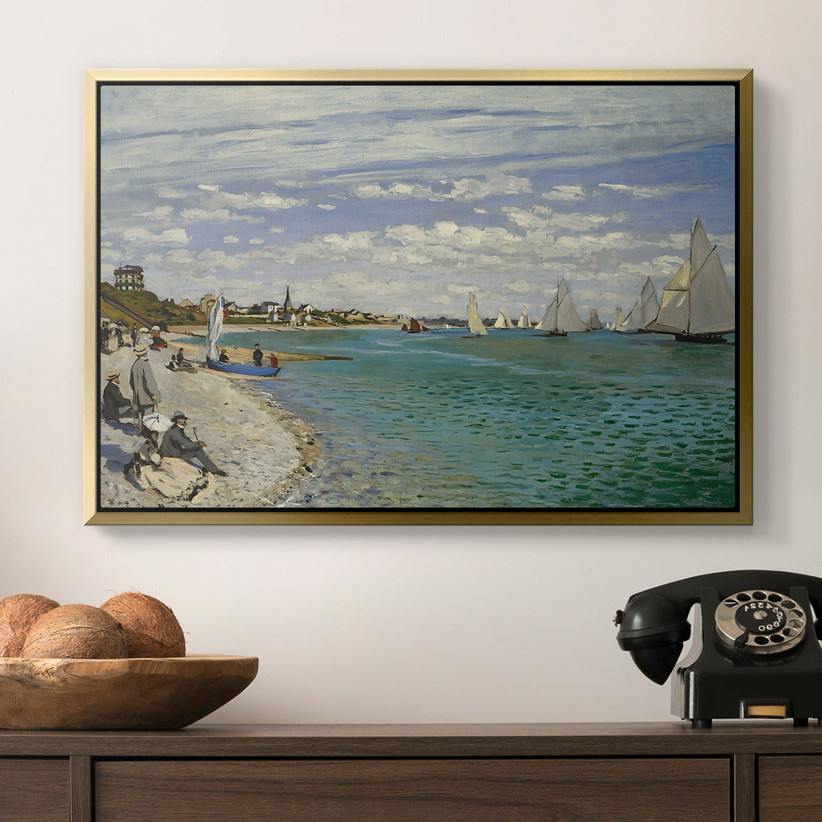 Regatta at Sainte-Adresse, 1867 by Claude Monet in a gold floater framed canvas displayed above a console table in a hallway, featuring a nautical scene with boats racing near seaside town.
