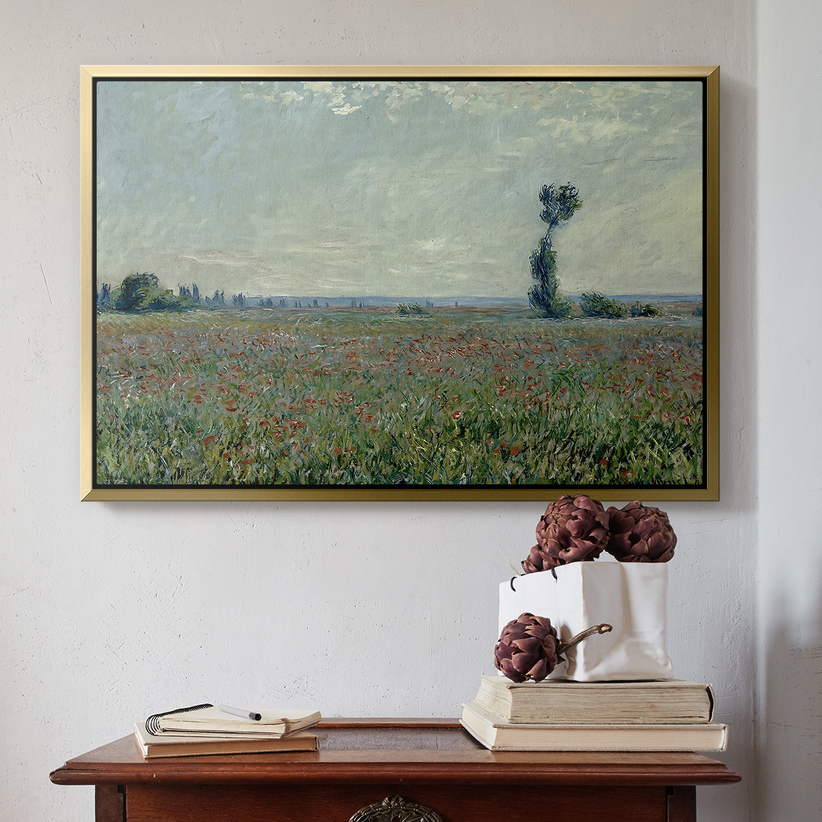 Gold floater framed canvas featuring Poppy Field, 1881 by Claude Monet above an entryway table in a minimalist foyer.