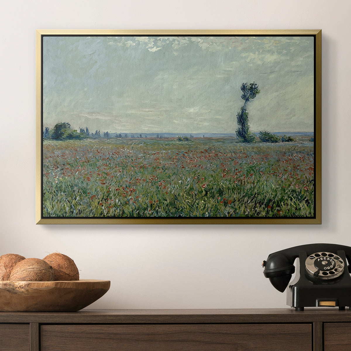Poppy Field, 1881 by Claude Monet in a gold floater framed canvas displayed above a console table in a hallway, featuring a natural field scene with vibrant red flowers.