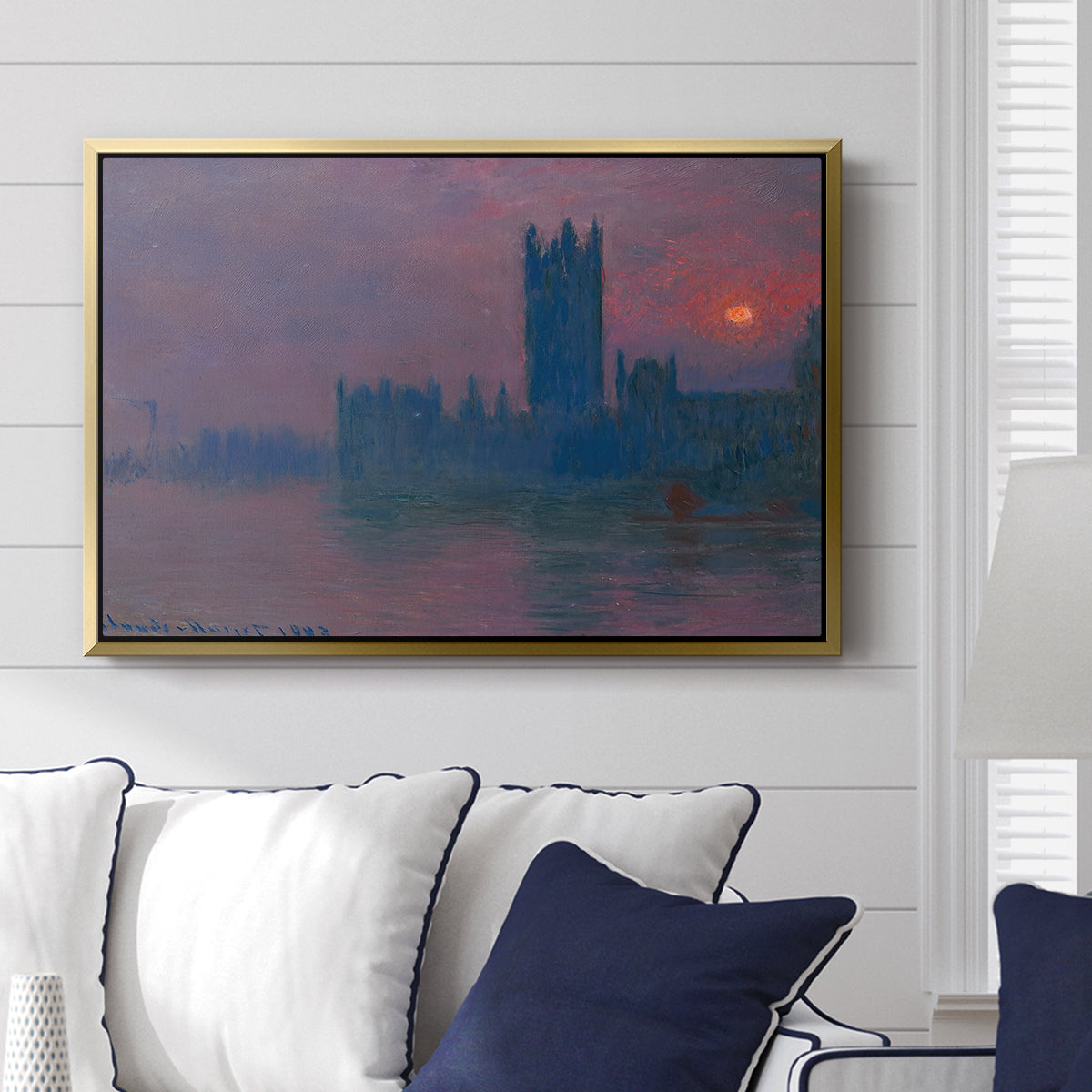 The Houses of Parliament, Sunset, 1903 by Claude Monet displayed above a sofa in a living room in a gold floater frame, featuring an impressionist cityscape with warm sunset light over water.