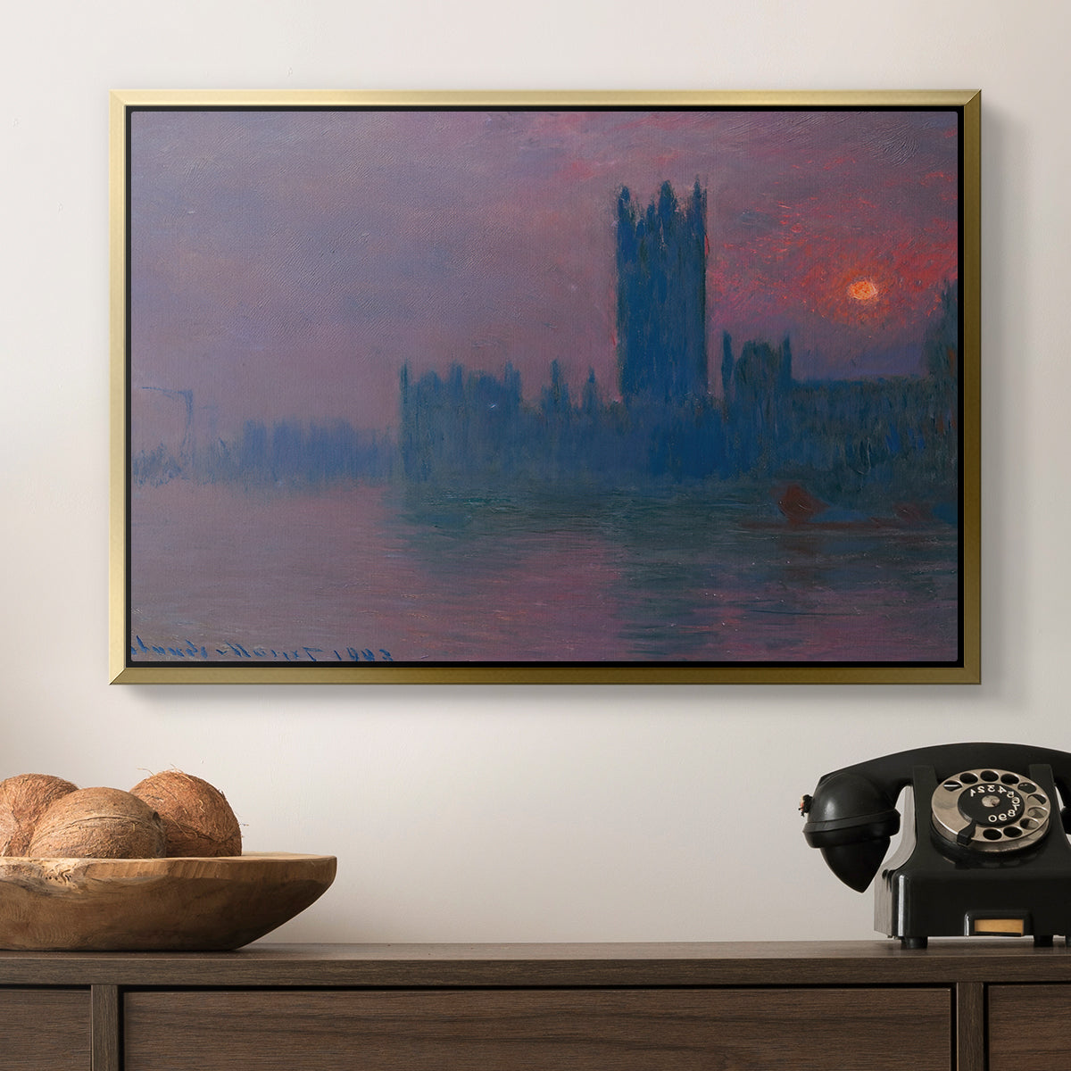 The Houses of Parliament, Sunset, 1903 by Claude Monet in a gold floater framed canvas displayed above a console table in a hallway, featuring a dramatic skyline with reflections under colorful sky.