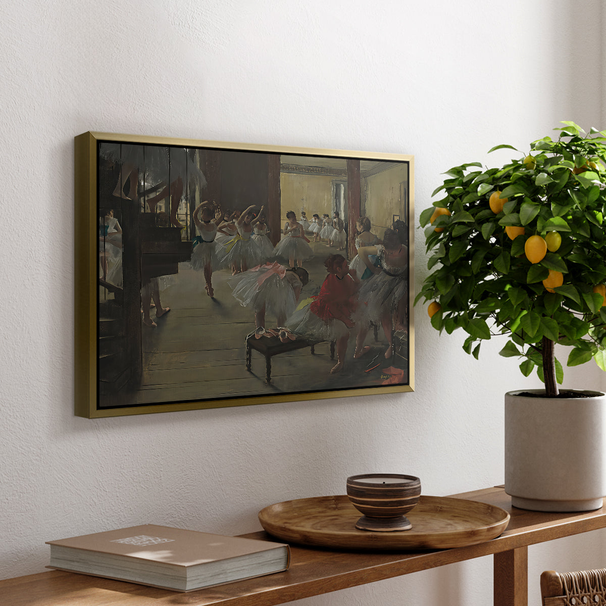 The Dance Class, c. 1873 by Edgar Degas, presented in a gold floater framed canvas featuring ballerinas practicing in studio with instructor observing nearby, displayed above a hallway console table.