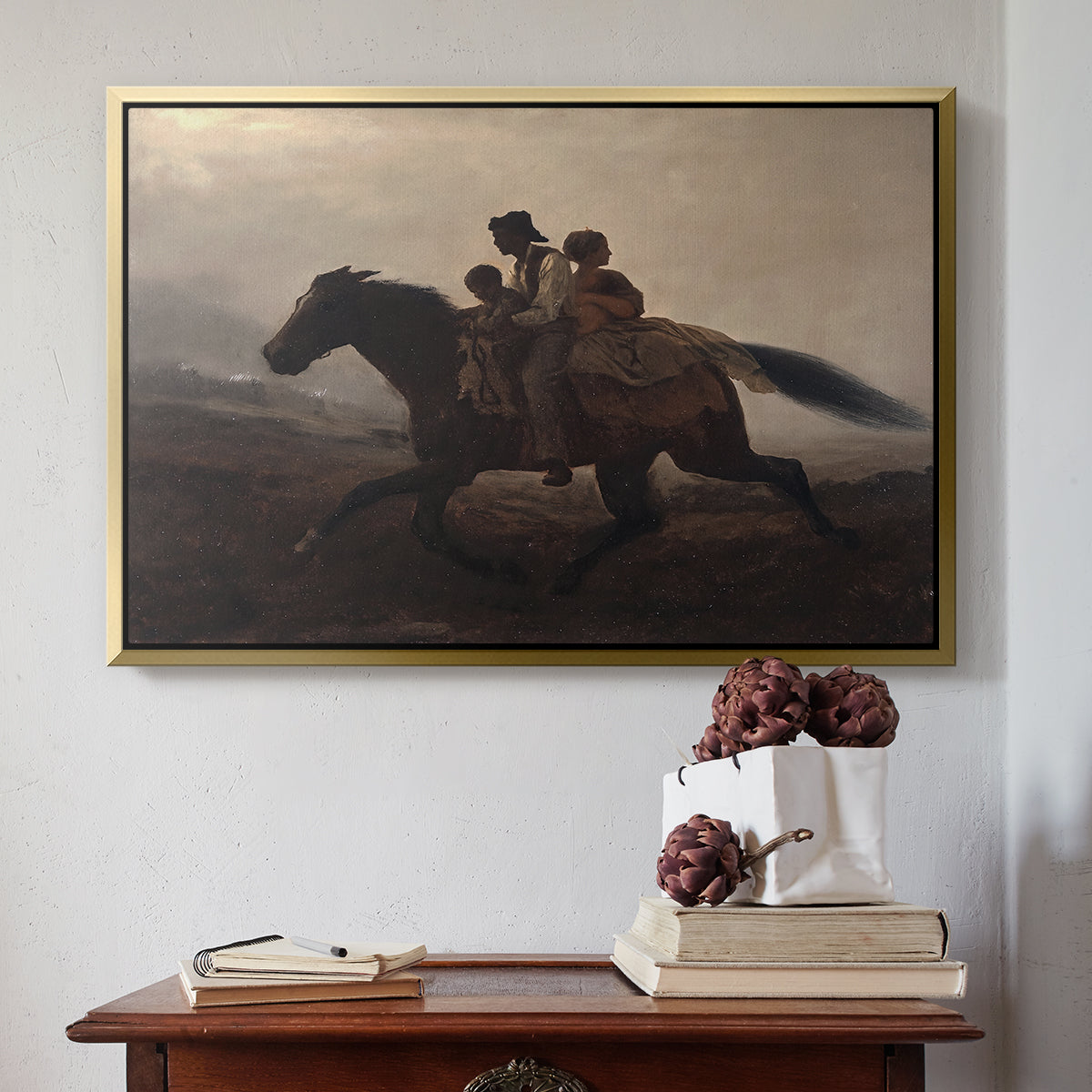 Gold floater framed canvas featuring A Ride for Liberty – The Fugitive Slaves, c. 1862 by Eastman Johnson above an entryway table in a minimalist foyer.