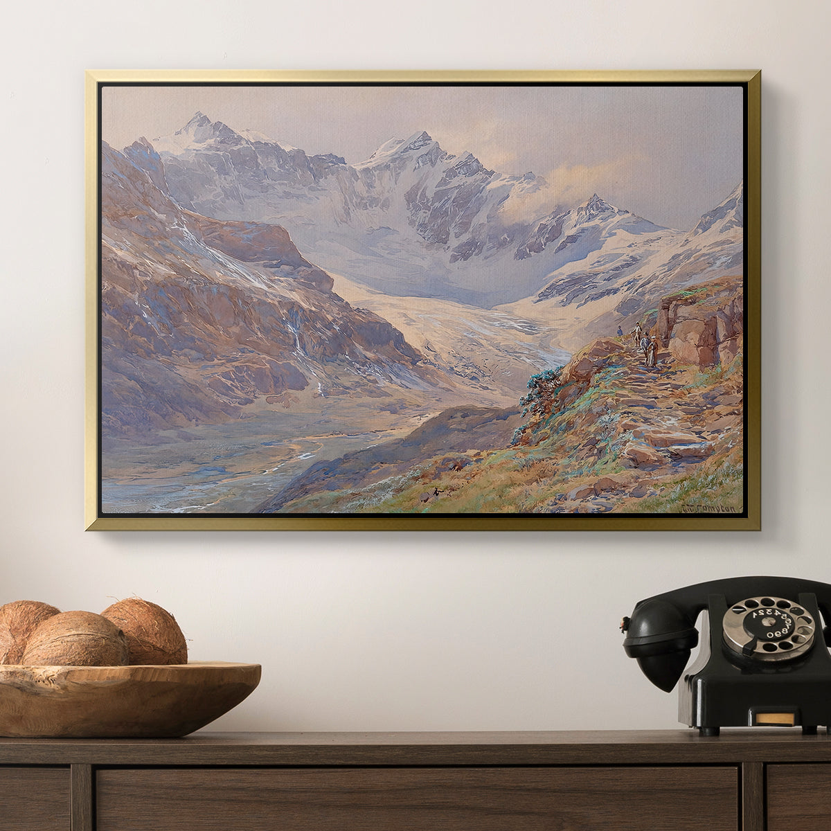 Odenwinklkees with the Johannisberg, 1902 by Edward Theodore Compton in a gold floater framed canvas displayed above a console table in a hallway, featuring an expansive alpine view with ice and distant mountains.