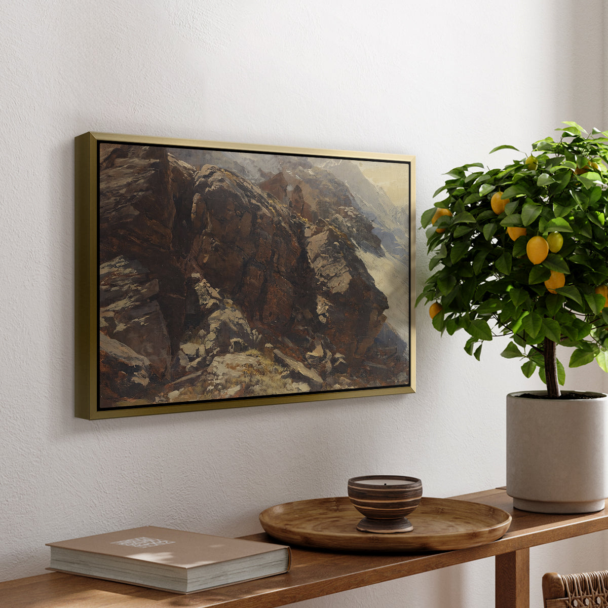 High Mountain Study, c. 1870 by Edward Theodore Compton, presented in a gold floater framed canvas featuring a rocky alpine terrain with steep slopes and distant mountain peaks, displayed above a hallway console table.