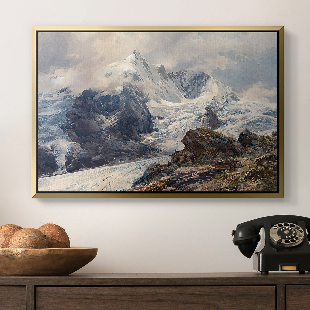The Grossglockner, 1880 by Edward Theodore Compton in a gold floater framed canvas displayed above a console table in a hallway, featuring an alpine peak dominating surrounding terrain.