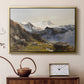 Gold floater framed canvas featuring an alpine vista with towering peak and foreground terrain, displayed above a cabinet in a soft-toned living room.