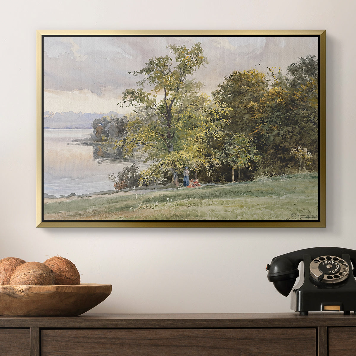 Landscape at Lake Starnberg, 1890 by Edward Theodore Compton in a gold floater framed canvas displayed above a console table in a hallway, featuring a tranquil lakeside view with soft atmospheric tones.