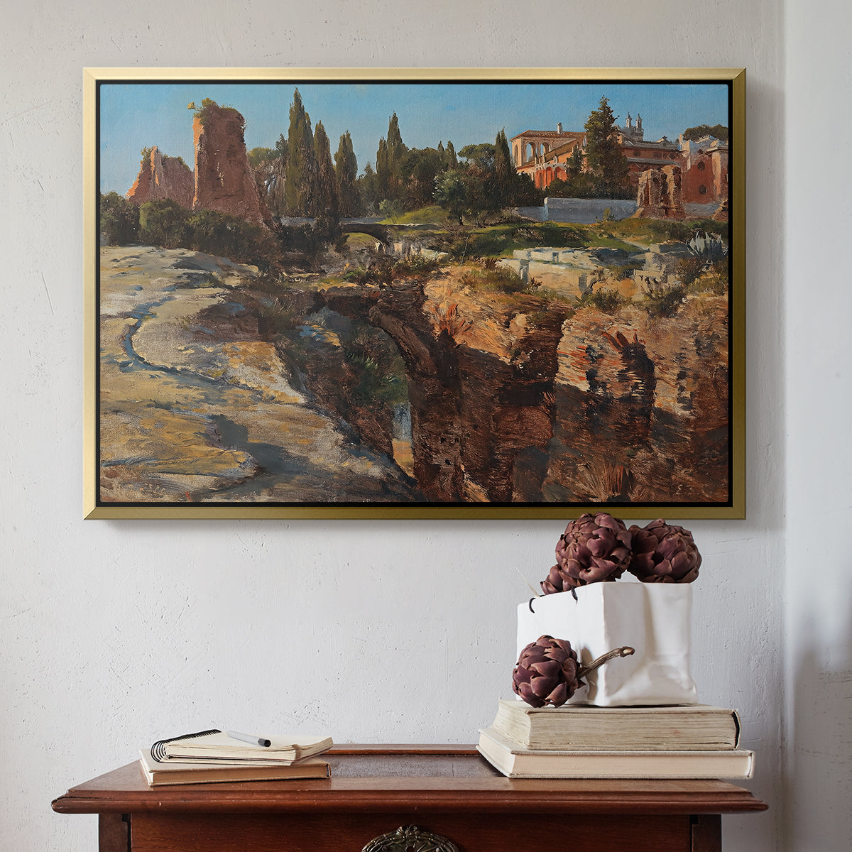 Gold floater framed canvas featuring Palatine in Rome, c. 1921 by Edward Theodore Compton above an entryway table in a minimalist foyer.