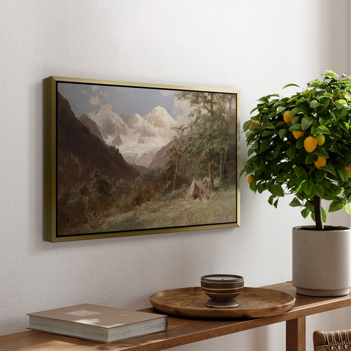 Landscape in the Caucasus, c. 1921 by Edward Theodore Compton, presented in a gold floater framed canvas featuring a mountainous landscape with rugged terrain and distant peaks, displayed above a hallway console table.
