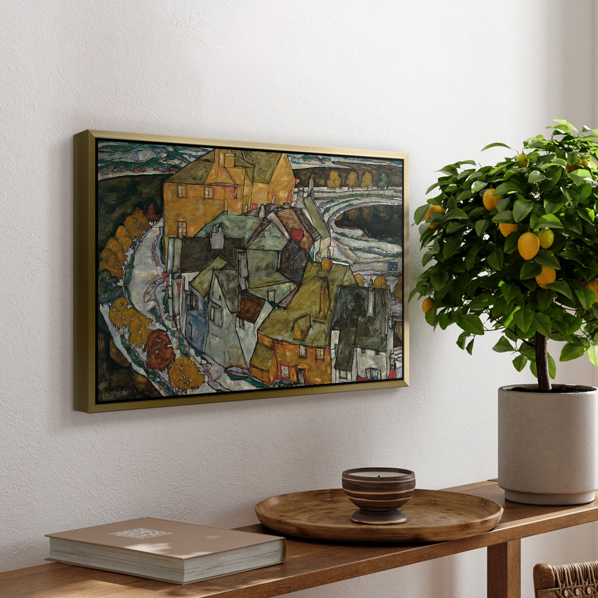 Crescent of Houses II (Island Town), 1915 by Egon Schiele, presented in a gold floater framed canvas featuring a curved row of colorful houses forming crescent shape along water, displayed above a hallway console table.