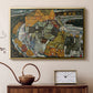 Gold floater framed canvas featuring an expressionist depiction of island town with geometric forms, displayed above a cabinet in a soft-toned living room.