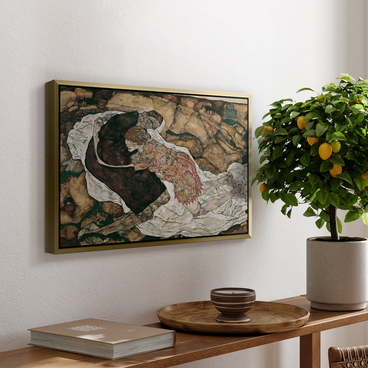 Death and the Maiden, 1915 by Egon Schiele, presented in a gold floater framed canvas featuring intertwined figures representing death and woman in emotional embrace, displayed above a hallway console table.