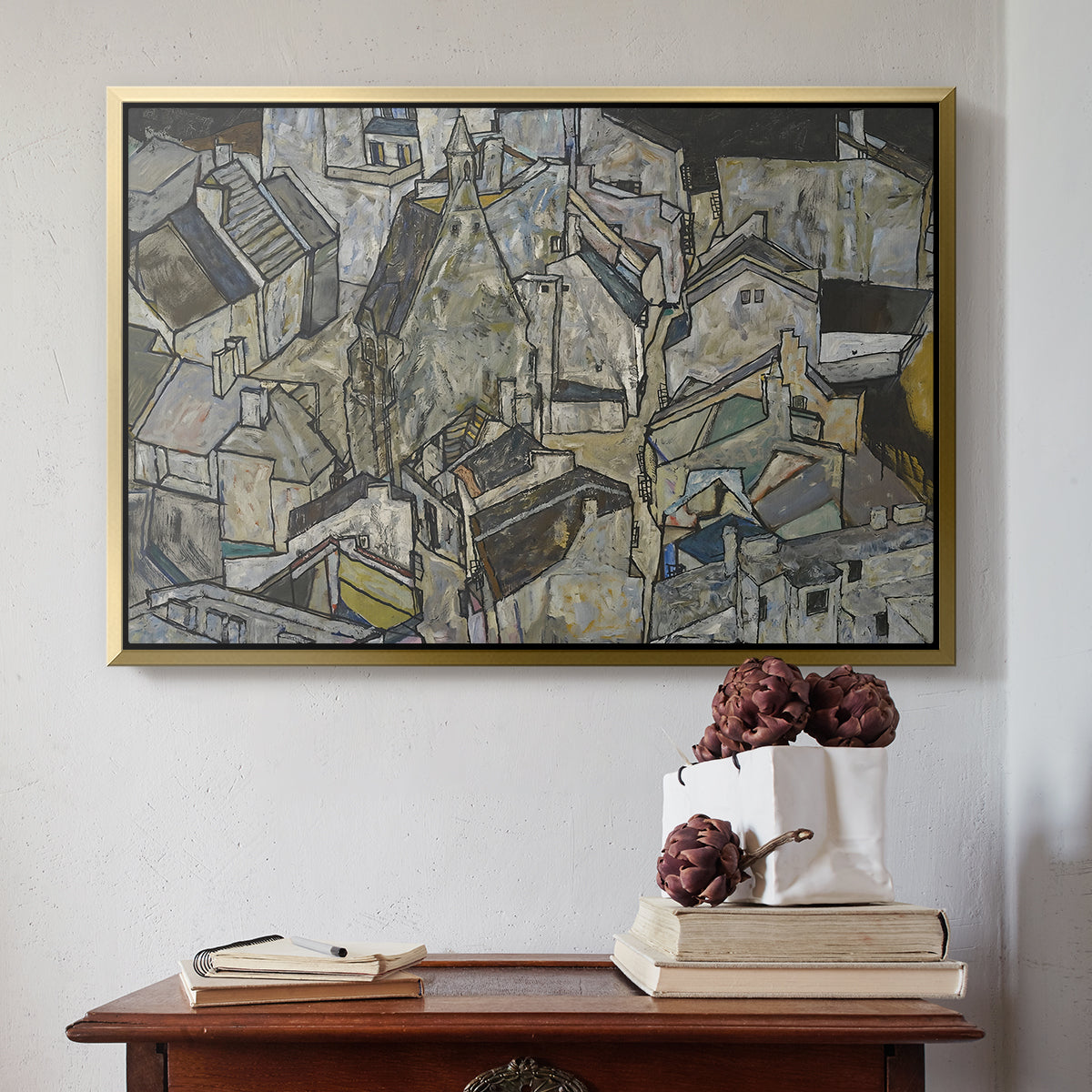 Gold floater framed canvas featuring Mödling II, 1918 by Egon Schiele above an entryway table in a minimalist foyer.