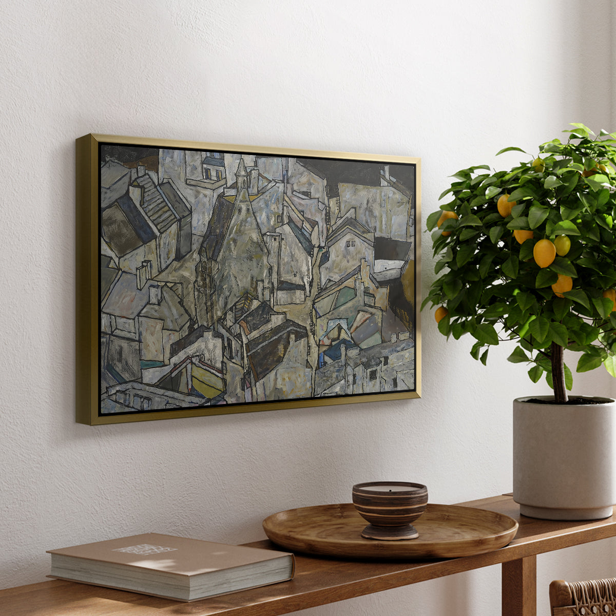 Mödling II, 1918 by Egon Schiele, presented in a gold floater framed canvas featuring clustered geometric houses forming dense urban landscape with sharp angles, displayed above a hallway console table.
