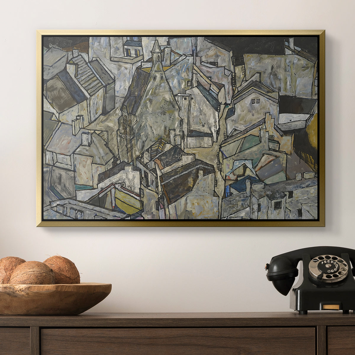 Mödling II, 1918 by Egon Schiele in a gold floater framed canvas displayed above a console table in a hallway, featuring a stylized urban composition with geometric structures and muted tones.